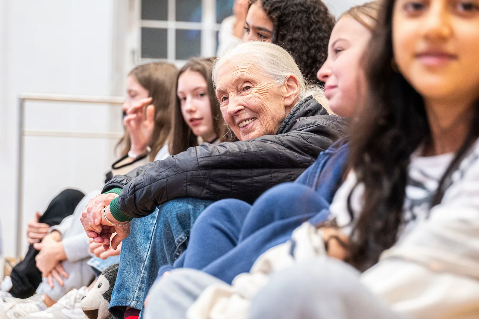 Jane Goodall seated with youth at a 2024 Roots  Shoots event in Salzburg 