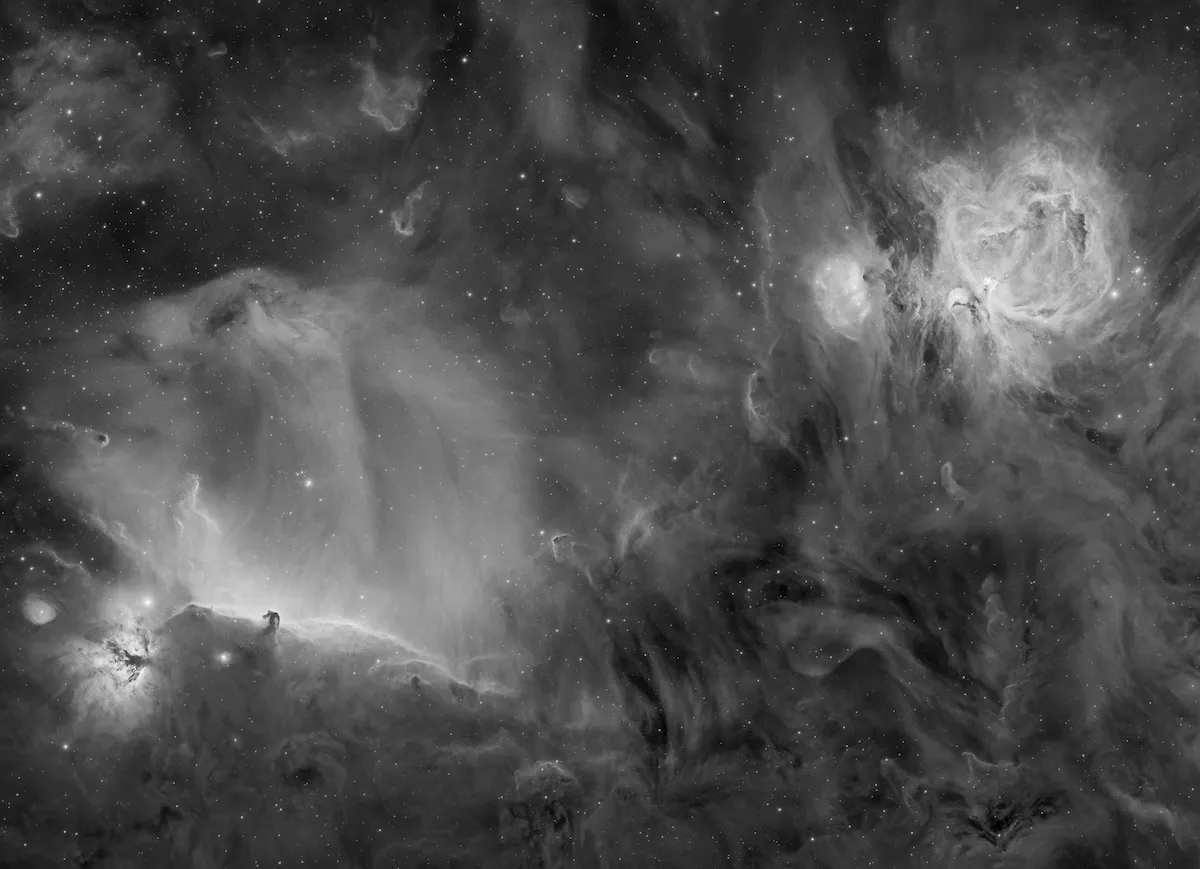 An image showing the Orion Horsehead and Flame nebulae in black and white highlighting their shapes and swirling gas clouds against the dark background of space